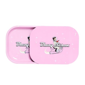May include: Pink rolling tray with a space-themed design featuring a woman in a spacesuit riding a rocket. The tray has the text "Blazy Susan" printed on it.