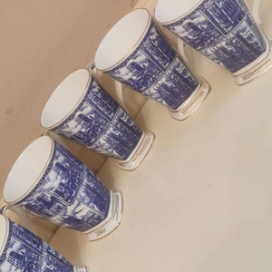 Peut inclure: Cinq tasses en céramique blanche avec des motifs bleus et dorés. Les tasses ont différentes années imprimées au fond, dont 2000 et Millennium.