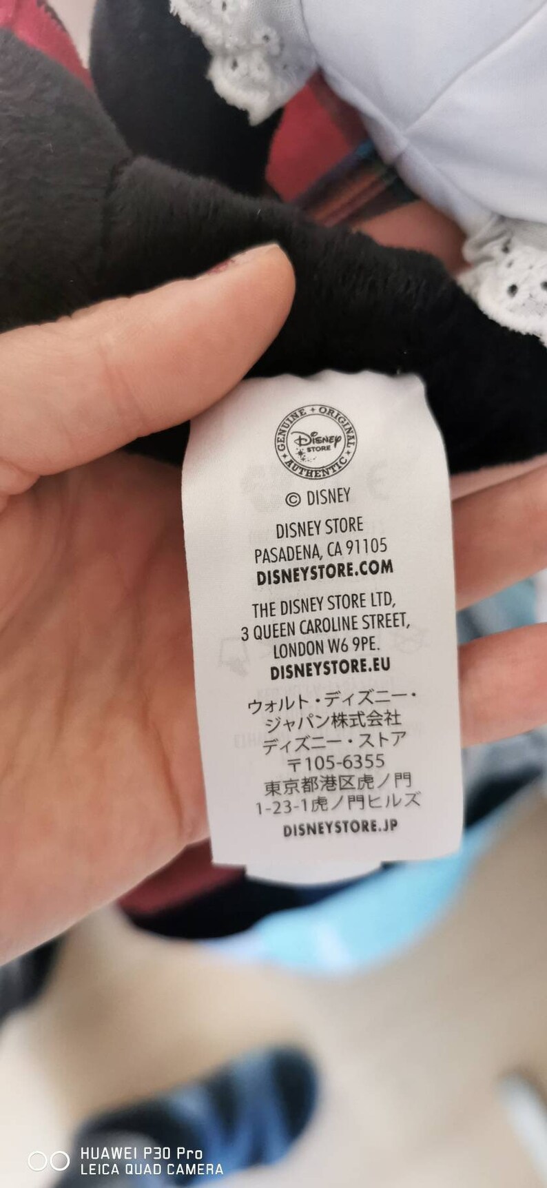 May include: White tag with black text listing the Disney Store locations in Pasadena, California, London, England, and Tokyo, Japan. The tag also includes the website addresses disneystore.com, disneystore.eu, and disneystore.jp.