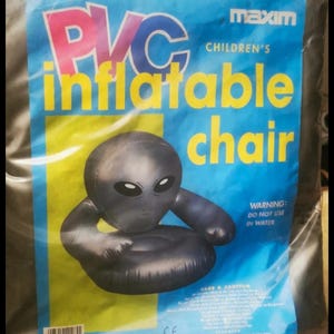 May include: A black and gray inflatable chair shaped like an alien head. The chair is packaged in a plastic bag with the words "PVC inflatable chair" and "maxim children's" printed on it. The bag also has a warning label that says "WARNING: DO NOT USE IN WATER".