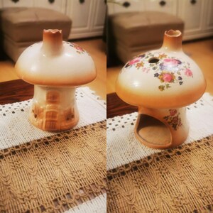 Pode incluir: Dois queimadores de incenso de cerâmica em forma de cogumelo. Um é branco com um design de casa e o outro é bege com desenhos florais.