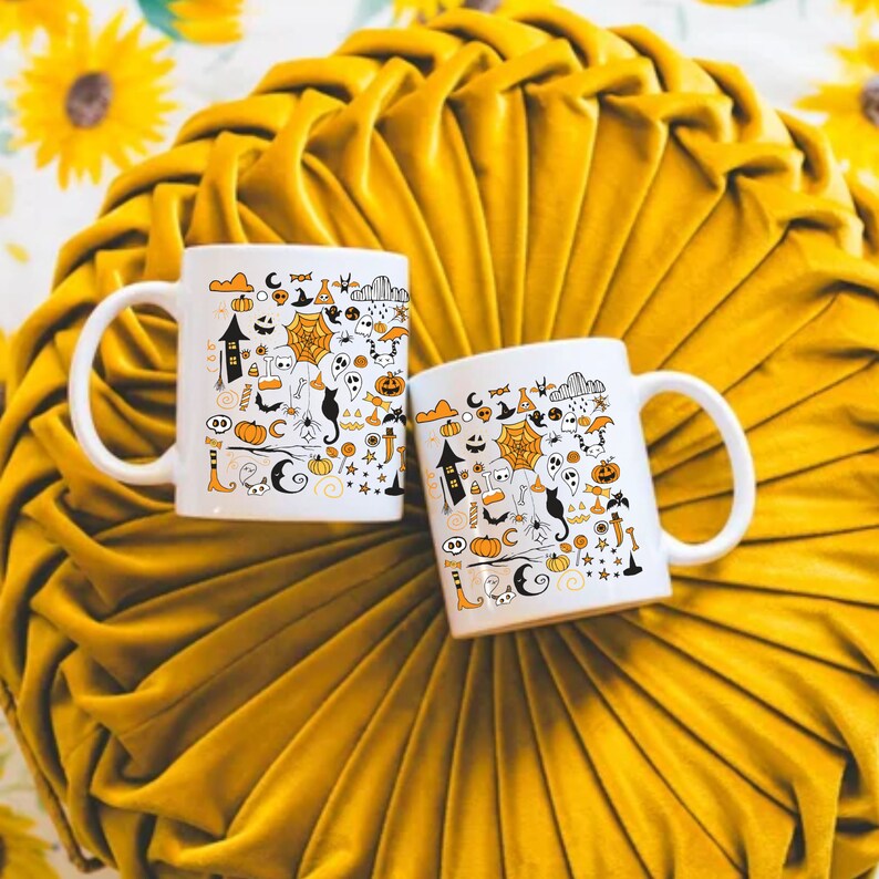 May include: Two white ceramic mugs with black handles. Both mugs feature a Halloween-themed design with black and orange illustrations of ghosts, pumpkins, bats, and other spooky elements.