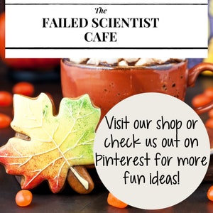 May include: A decorated gingerbread cookie shaped like a maple leaf with red, yellow, and green icing. The cookie is next to a mug of hot chocolate with marshmallows and a white circle with the text "Visit our shop or check us out on Pinterest for more fun ideas!"