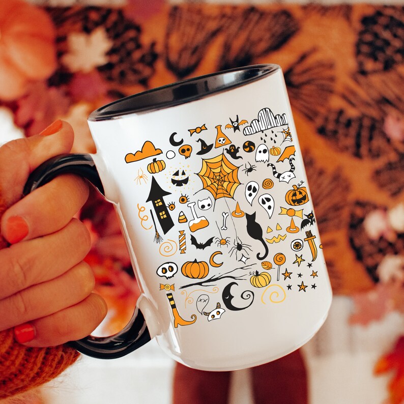 May include: White ceramic mug with a black rim and handle. The mug features a black and orange Halloween-themed design with various spooky icons, including ghosts, bats, spiders, pumpkins, and a witch's hat.