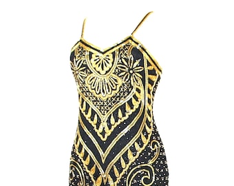 May include: A black midi-length dress featuring intricate gold sequin and bead embroidery in a floral and geometric pattern. The garment has thin spaghetti straps, a V-neckline, and a front slit at the hem, with a dense application of gold embellishments throughout the dark fabric surface.