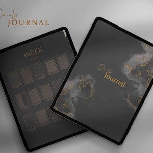 以下が含まれることがあります： 金とグレーの大理石のデザインと「Daily Journal」というテキストが書かれた黒いデジタルタブレット。タブレットは、「INDEX」という単語と正方形のグリッドが書かれたページを開いています。