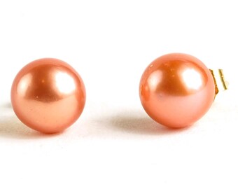 May include: A pair of peach-colored pearl stud earrings.