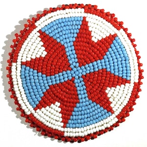 May include: A round beaded design with a red, white, and blue pattern. The beads are arranged in a circular pattern, creating a spiral effect.