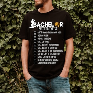 May include: A black t-shirt with a white graphic that says "Bachelor Party Checklist" and lists a humorous checklist of things to do at a bachelor party.