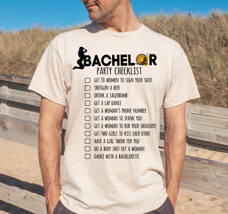 May include: A beige t-shirt with a checklist for a bachelor party. The checklist includes items like "Get 10 women to sign your shirt" and "Dance with a bachelorette".