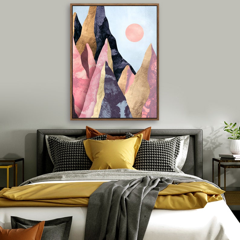 May include: A framed abstract art print featuring a mountain range with pink, gold, and purple hues against a light blue sky with a pink sun.