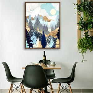 May include: A framed abstract landscape painting with a blue, gold, and white color scheme. The painting depicts a forest with trees and mountains in the background. The sky is a light blue with white clouds.