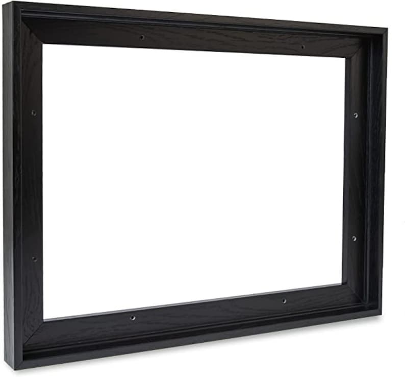 Puede incluir: Un marco de fotos rectangular de madera negra con una textura de veta de madera visible. El marco tiene un perfil profundo y agujeros pretaladrados para el montaje. El interior est&aacute; vac&iacute;o.