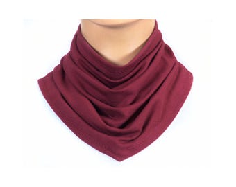 May include: A burgundy neck warmer made of soft fabric. The neck warmer is folded and gathered to create a cozy and stylish look.