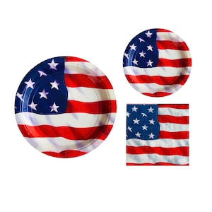 May include: Three paper plates and a napkin featuring an American flag design. The plates and napkin are white with red and blue stripes and white stars.