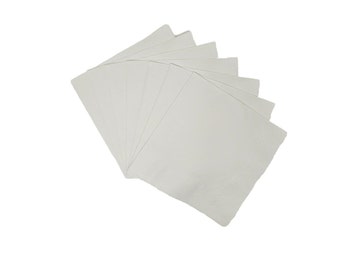 Puede incluir: Un paquete de servilletas de papel blancas, dobladas y dispuestas en forma de abanico.
