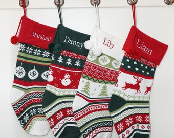 May include: Four Christmas stockings with personalized names: Marshall, Danny, Lily, and Liam. Each stocking features a festive knit design in red, green, and white, with snowflake, snowman, and reindeer patterns. They hang from decorative hooks.