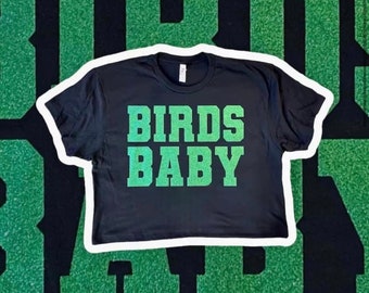 May include: Black cropped t-shirt with the text "BIRDS BABY" in green glitter lettering.