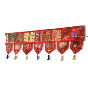 May include: A red and multi-coloured fabric door hanging with tassels. The fabric is made of patchwork pieces with embroidery. The door hanging has the text "Saniya Creations" in the top right corner.