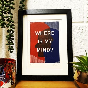 May include: A framed print with a red and blue silhouette of a person's head. The text "WHERE IS MY MIND?" is printed in white on the print.