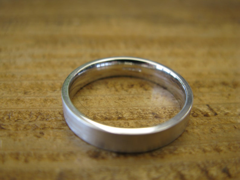 May include: A simple silver wedding band with a brushed finish.