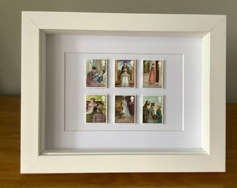 May include: A white frame with six vintage postage stamps featuring illustrations from Jane Austen novels. The stamps are arranged in two rows of three. The stamps feature illustrations of characters from Pride and Prejudice, Sense and Sensibility, Emma, Persuasion, Northanger Abbey, and Mansfield Park.