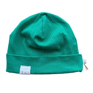 Peut inclure: Un bonnet côtelé vert avec une étiquette blanche qui dit "J.Crew!"