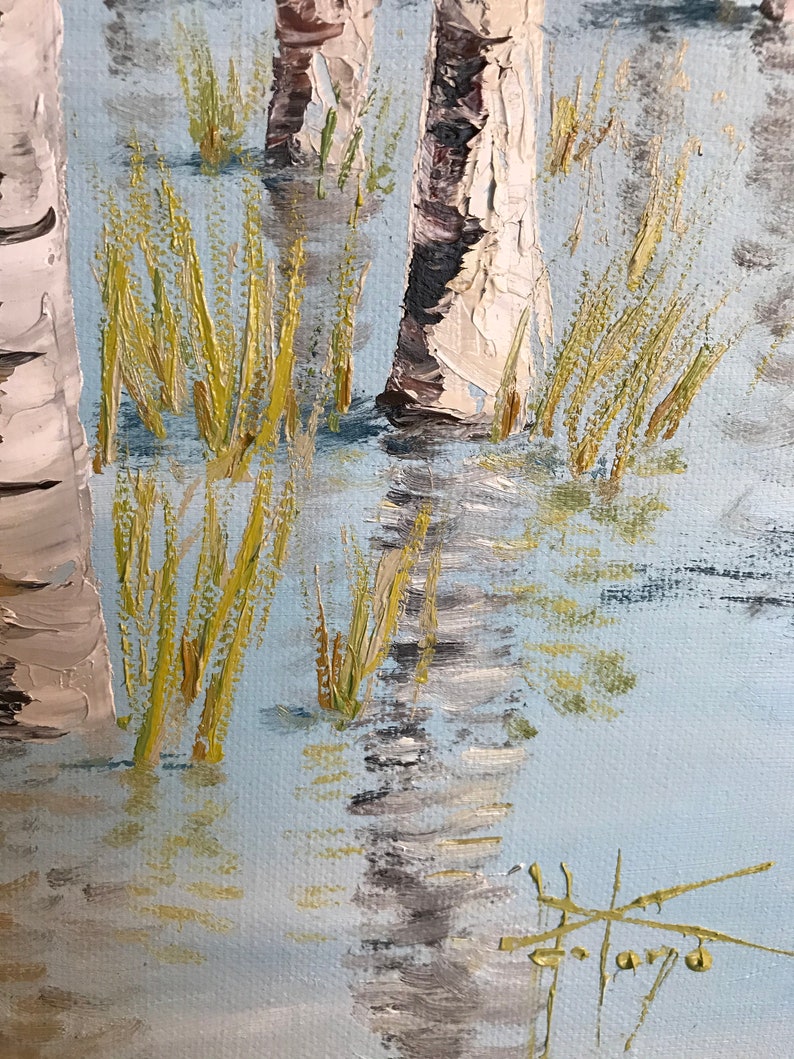 May include: A close-up of a painting depicting a birch forest with white bark and green foliage. The trees are reflected in the water, which is painted in shades of blue and gray. The painting is done in a realistic style with visible brushstrokes.