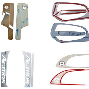 May include: An assortment of automotive trim pieces, including door handle covers and pillar accents. Some pieces are chrome, others are silver with protective film. The Mercedes-Benz logo is visible on several components. The Actros logo is also present.