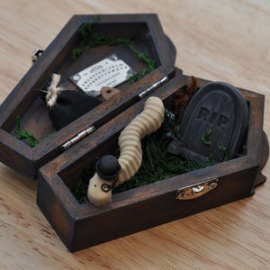 Peut inclure: Ensemble de trois mugs en céramique avec une finition mate et mouchetée. Les tasses sont de couleur crème, gris clair et gris foncé. Design minimaliste, parfait pour le café ou le thé.