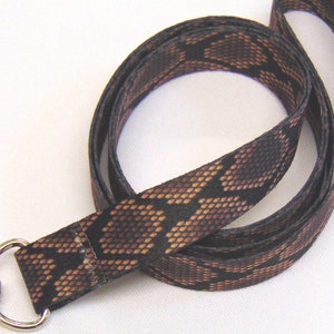 May include: A black and brown snake skin patterned lanyard with a silver swivel clip and a silver ring.