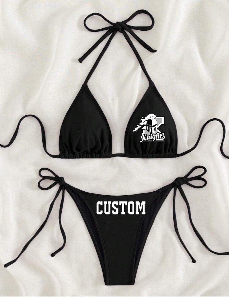May include: Black bikini with a custom design. The top has a white knight logo with the text "Knights" and the bottom has the word "CUSTOM" printed in white.