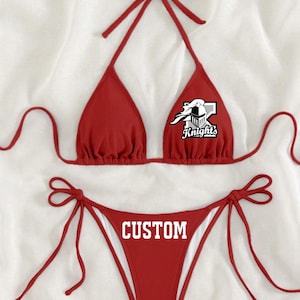 May include: Red bikini with a white logo that says "Knights" on the top and "CUSTOM" on the bottom.