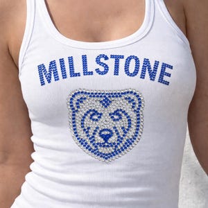 Puede incluir: Camiseta sin mangas blanca acanalada con la palabra "MILLSTONE" en pedrería azul en el pecho. Debajo del texto hay un diseño de oso hecho de pedrería azul y plateada. La camiseta sin mangas tiene cuello redondo y silueta ajustada.