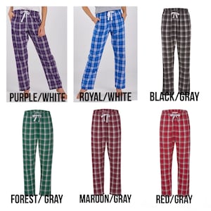 May include: Plaid pajama trousers in a range of colours: purple, royal blue, black, forest green, maroon, and red. Each pair has a white drawstring and a relaxed fit. The image text reads: PURPLE/WHITE, ROYAL/WHITE, BLACK/GRAY, FOREST/GRAY, MAROON/GRAY, RED/GRAY.