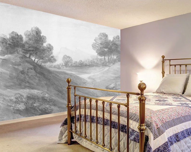 Puede incluir: Un mural de paisaje en blanco y negro que representa una colina ondulada con &aacute;rboles y un camino. El mural est&aacute; en una pared de un dormitorio con una estructura de cama de lat&oacute;n y una colcha con estampado blanco y azul.