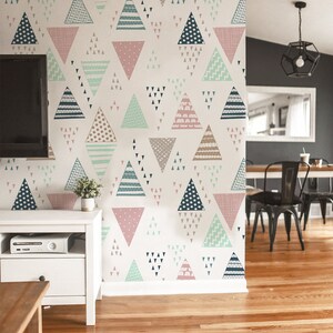 Könnte beinhalten: Eine Wand mit einem sich wiederholenden Muster aus bunten Dreiecken in verschiedenen Designs und Farben, darunter Rosa, Blau und Beige. Die Dreiecke sind auf einem weißen Hintergrund angeordnet und erzeugen ein modernes, geometrisches Design. Der Raum hat Holzböden.