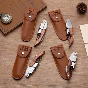 May include: Set of five personalized leather-wrapped bottle openers with wooden handles. Each opener has a different name and design engraved on the handle. The openers are displayed on a wooden surface.
