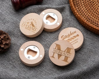May include: Four wooden bottle openers with engraved designs. One opener features a mountain range with the text "Luciano Since 2024". Another opener has a tie and the text "Stephen Groomsman 01.12.2024". The third opener has a large "M" with the text "Mercado" below it. The fourth opener has a simple design with a metal bottle opener.
