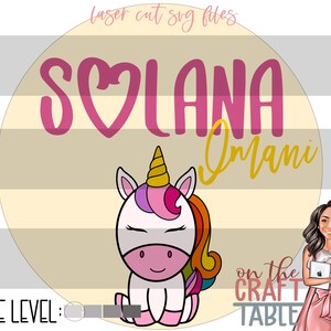 May include: A round, yellow and beige background with the text "Solana Omani" in pink and yellow. A cartoon unicorn with a pink horn, purple mane, and yellow tail is in the center of the circle. The text "on the CRAFT TABLE" is below the unicorn.
