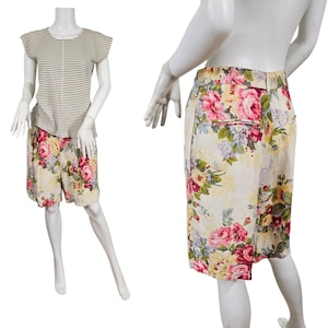 Puede incluir: Un conjunto de dos piezas en un maniquí. La parte superior es una camisa de manga corta a rayas. Los pantalones cortos tienen un estampado floral con rosas rosas y amarillas. El conjunto se exhibe en un maniquí blanco.