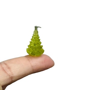 May include: A small, green, glass Christmas tree ornament with a silver top.