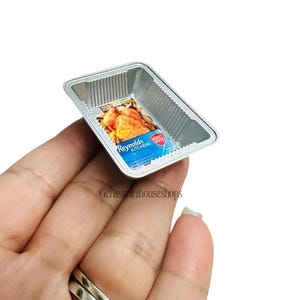May include: Miniature Reynolds Kitchens heavy duty foil baking tray with a label showing a roasted chicken. The tray is rectangular with a corrugated design. The label is blue and white.