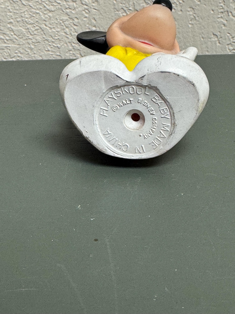 May include: A vintage Playskool Baby Mickey Mouse figurine. The bottom of the white figurine has the text "Playskool Baby Made in China Walt Disney Company". The figure has a yellow shirt and black ears.