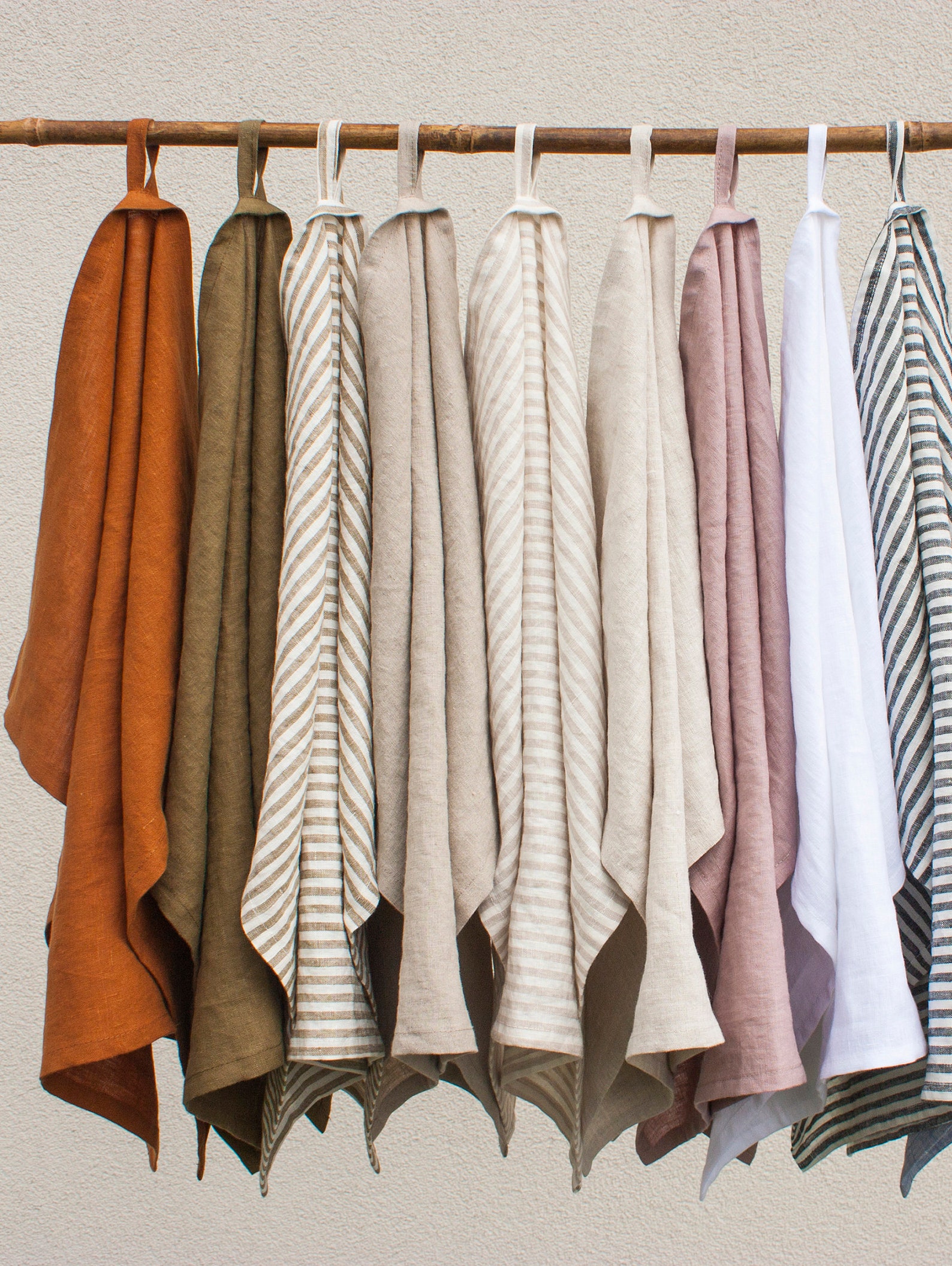 A collection of stonewashed linen tea towels hanging up.