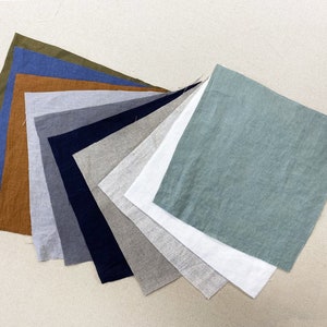 May include: A collection of ten fabric swatches in various colours, including green, blue, brown, grey, white, and beige. The swatches are arranged in a fan shape, with the green swatch at the top and the beige swatch at the bottom.