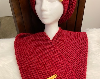 May include: A red knitted hat and matching scarf with fringe. The hat has a small brown leather tag with the text "LoveKnitting" on it. The scarf also has a brown leather tag with the text "LoveKnitting" on it.