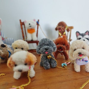 May include: A group of miniature toy dogs with various fur colours and features. Some have leashes and collars, while others are seated on miniature chairs. The dogs are arranged on a wooden surface.