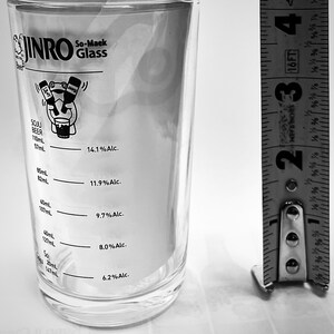 Puede incluir: Un vaso transparente de So-Maek con medidas impresas y un gr&aacute;fico de dibujos animados. El vaso mide aproximadamente 15 cm de alto. El vaso tiene medidas para Soju y Cerveza, con indicadores de porcentaje de alcohol.