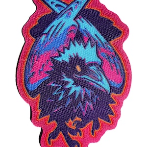 May include: An embroidered patch featuring a stylized dark purple raven with a bright blue crest and beak. The bird is positioned against a vibrant pink background with a blue wing shape above its head, outlined in orange and pink thread borders.